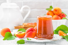 Apricot Jam In A Jar And Fresh Fruits With Leaves On White Wooden Table, Breakfast