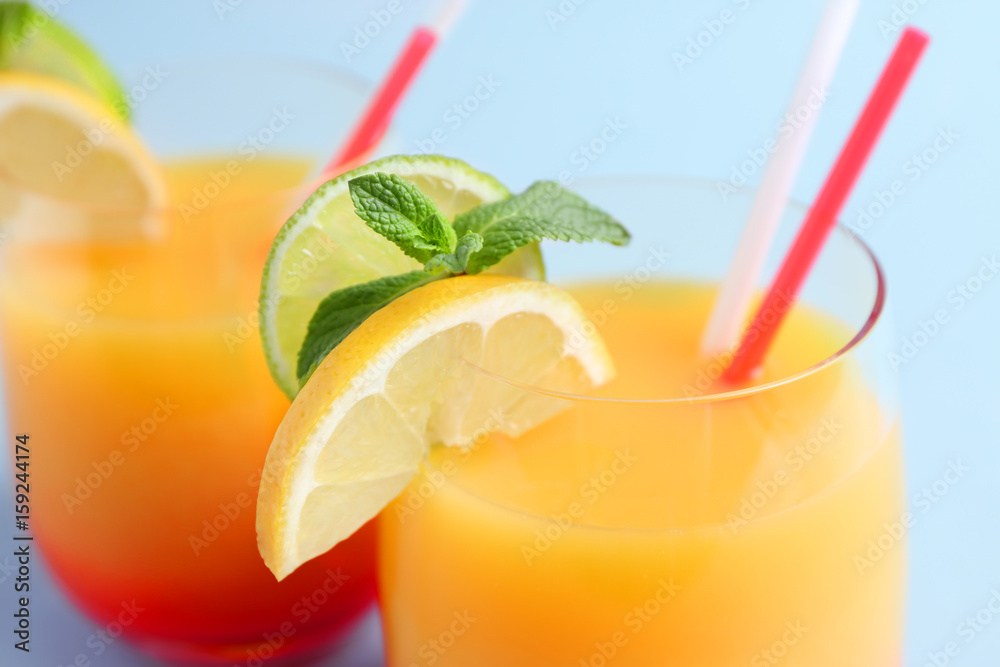 Glasses of Tequila Sunrise cocktail on light background