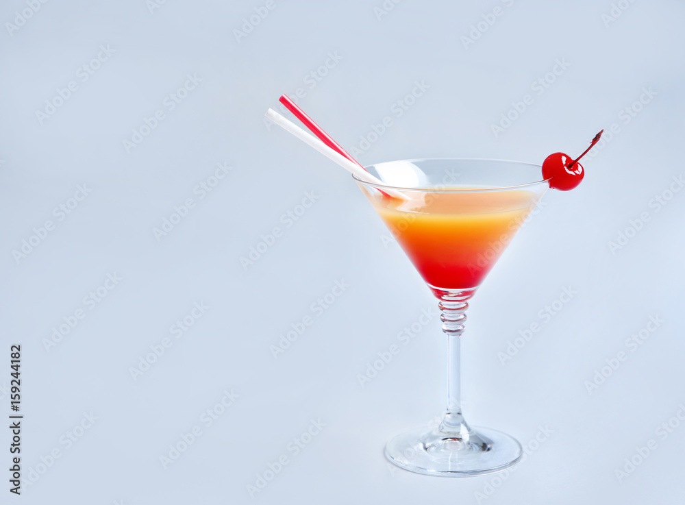 Glass of Tequila Sunrise cocktail on light background