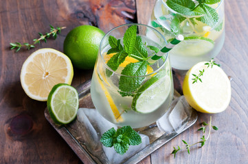 Refreshing cold iced mint drink with lemons and lime, summer drink with ice, selective focus, toned image