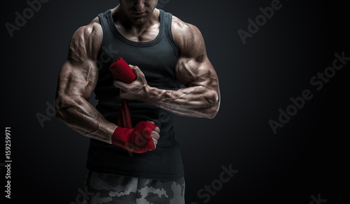 Foto Strong man wrap hands on black background Man is wrapping hands with red boxing