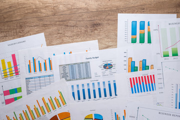 many different business graph  with calculator and pen on desk.