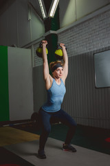 Fitness woman training by kettlebell. Fit young lady doing crossfit exercise.