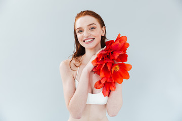 Poster - Close up portrait of a redheaded woman holding tulip flowers