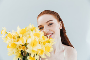 Poster - Close up portrait of a redheaded woman holding narcissus flowers