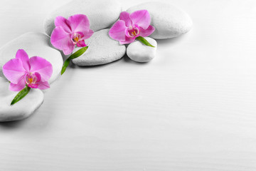 Wall Mural - Spa stones with orchid flowers and bamboo leaves on white background