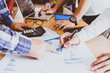 © doidam10 - Business people brainstorming at office desk, they are analyzing financial reports and pointing out financial data on a sheet