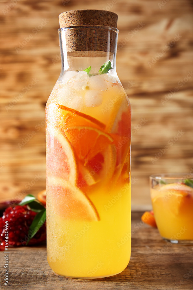 Decanter of fresh citrus cocktail on table