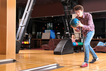 Wall Mural - Young man having fun in bowling club