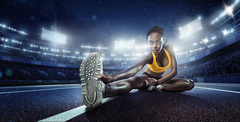 Wall Mural - Sport. Runner stretching on the running track. The stadium on the background