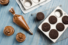 Decorating Chocolate Cupcakes With Chocolate Buttercream Frosting In Pastry Bag