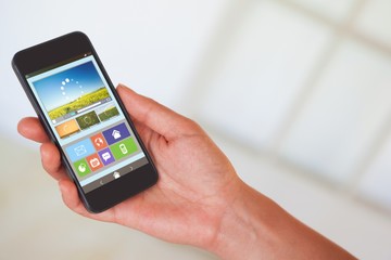 Poster - Composite image of womans hand holding black smartphone