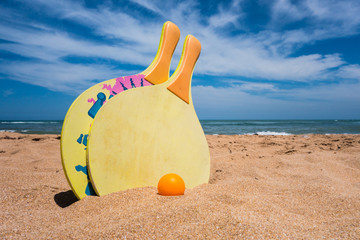 close-up view of beach rackets and ball in the sand