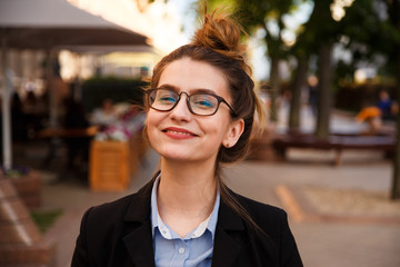 business woman in suit portrait during travel for company meeting outdoor brunette with glasses.