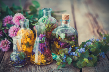 Wall Mural - bottles of tincture or infusion of healthy herbs, healing herbs on table. herbal medicine.