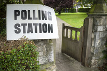 British Election Polling Station Sign Hanging On Post Next To An Open Gate And Hedge In The UK