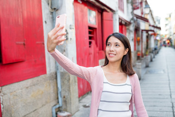 Wall Mural - Woman taking selfie in Rua da Felicidade of Macao