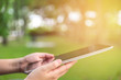 © kwanchaift - woman using tablet whilte sitting for relax in green park