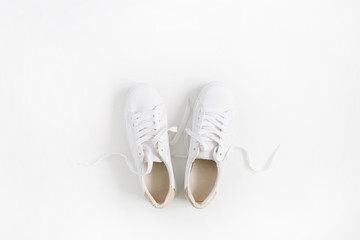 Wall Mural - White female sneakers isolated on white background. Flat lay, top view