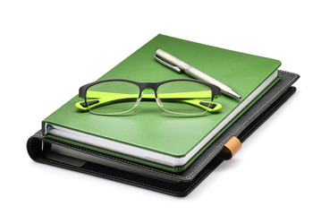 green notebook with green glasses and silver pen isolated on whtie background, office concept