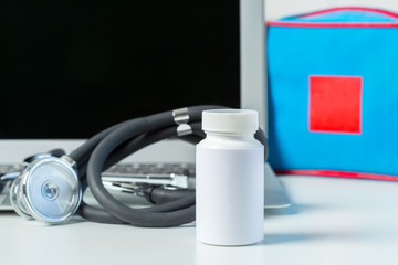 Wall Mural - Stethoscope, laptop and pills on the white table