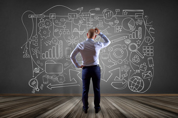 Poster - businessman drawing a hand drawn complex schema on a wall - network and communication concept