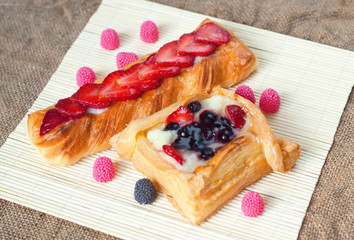 Wall Mural - Pastries with berries on a wooden background. Summer fruit dessert.