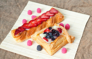 Wall Mural - Pastries with berries on a wooden background. Summer fruit dessert