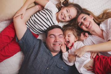 Wall Mural - young family lying in bed at home