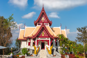 Temple with red art pattern and yellow naga in Cloud and blue sky day