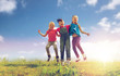 © Syda Productions - group of happy kids jumping high on green field