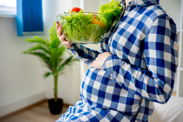 Wall Mural - Pregnant woman eating vegetables