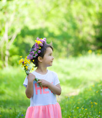 Wall Mural - Portrait of a cheerful girl with a wreath of flowers on her head