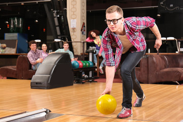 Poster - Young man having fun and playing bowling