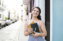 Puerto Rico, San Juan, Cheerful Woman With Digital Tablet And Notebook Walking City Streets