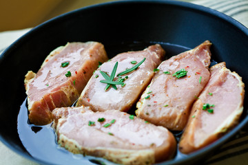 Pork steaks with herbs in pan, fresh fillets for grilling, baking. Raw organic meat. 