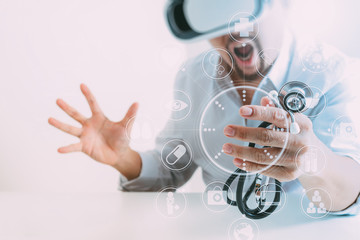 smart doctor wearing virtual reality goggles in modern office with mobile phone using with VR headset with screen icon diagram