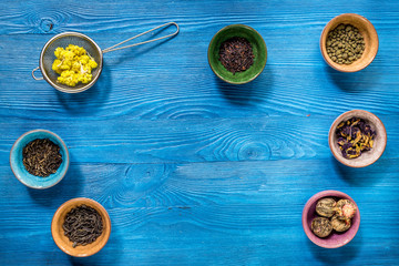 Wall Mural - Different kinds of herbal tea on blue background top view mockup