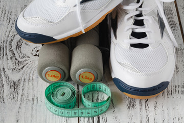 sport shoes and dumbbells on the floor, top view. Sport background