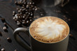 capucino foam in coffe cup, coffee beans in the dark background