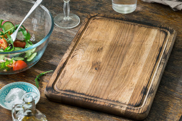 Canvas Print - Empty kitchen board with bowl of salad on wooden table