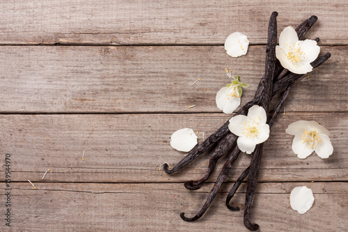 Fotografía Vanilla sticks with flower and leaf on a old wooden background with copy space for your text