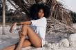 © zolotareva_elina - beautiful young african american girl sitting on sand at the beach