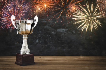 Wall Mural - low key image of trophy over wooden table and dark background