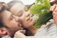 Close Up Portrait Of Young Couple Holding Bouquet Of Flowers