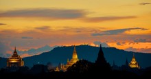 Sunset Over Bagan With Illuminated Pagodas And Golden Sky