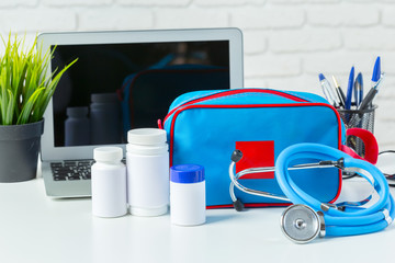 Wall Mural - Stethoscope, laptop and pills on the white table