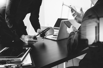 co working meeting,two businessman using VOIP headset with latop computer on desk in modern office as call center and customer service help desk concept,black and white