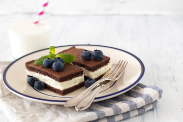 Wall Mural - Chocolate biscuit with milk filling and berries on a plate. Chocolate-milk kids dessert.