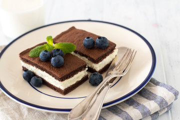 Wall Mural - Chocolate biscuit with milk filling and berries on a plate. Chocolate-milk kids dessert.